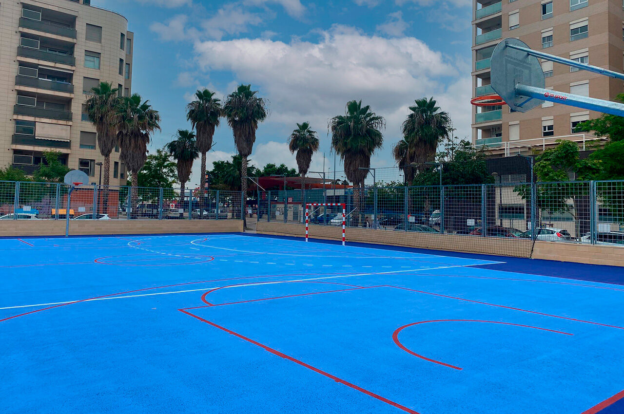 Pista polideportiva municipal de barrio en València, con canasta de baloncesto y portería de fútbol sala