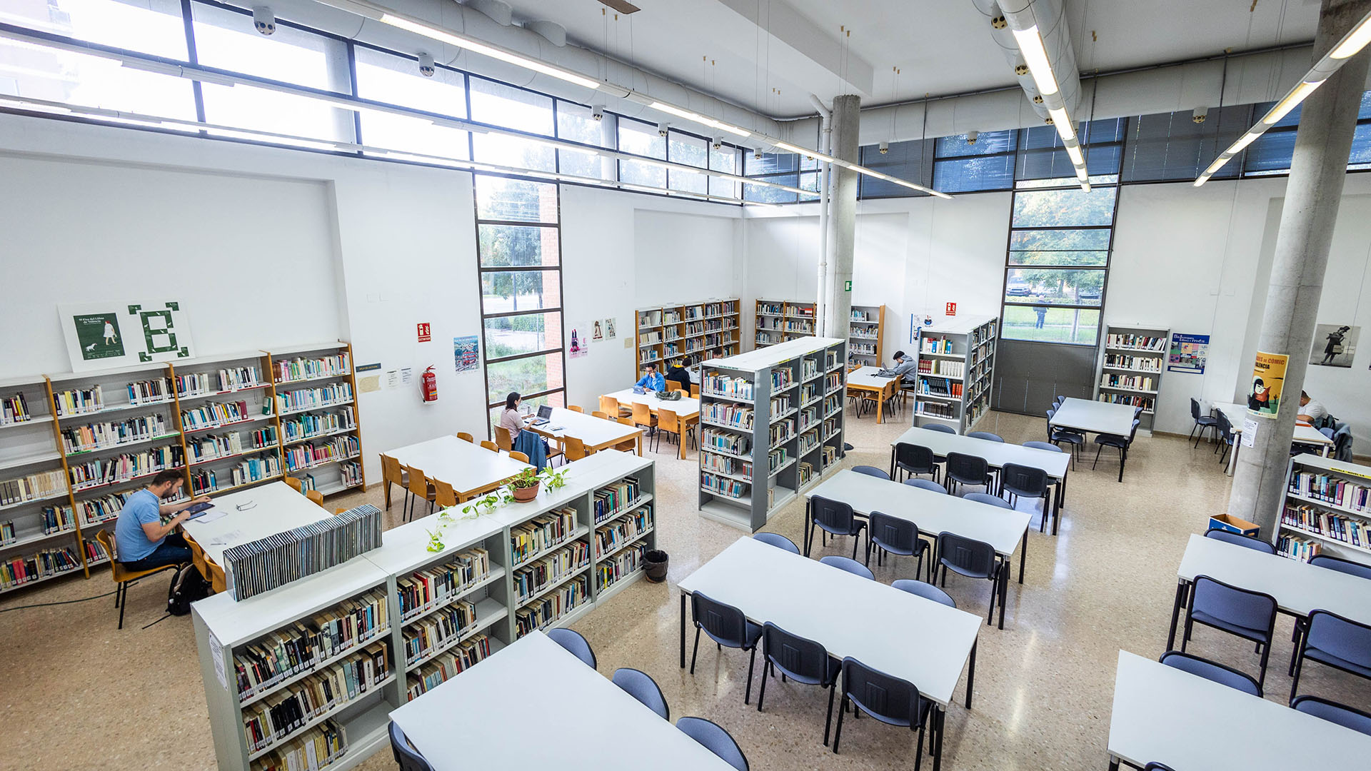 Sala de lectura de la biblioteca municipal Joan de Timoneda, con estanterías, mesas de estudio y luz natural